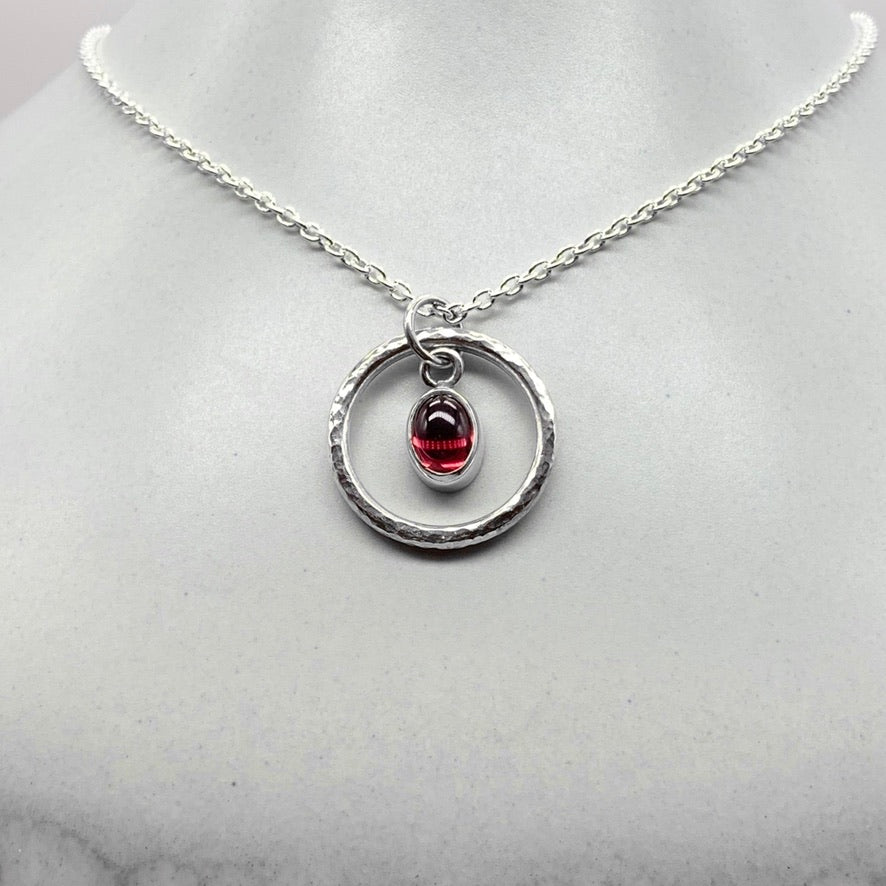 Oval cabochon rhodalite garnet pendant necklace in silver hammered ring